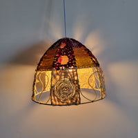 Handwoven raffia lamp shade designed with vibrant colors, perfect for boho chic lighting statement piece.