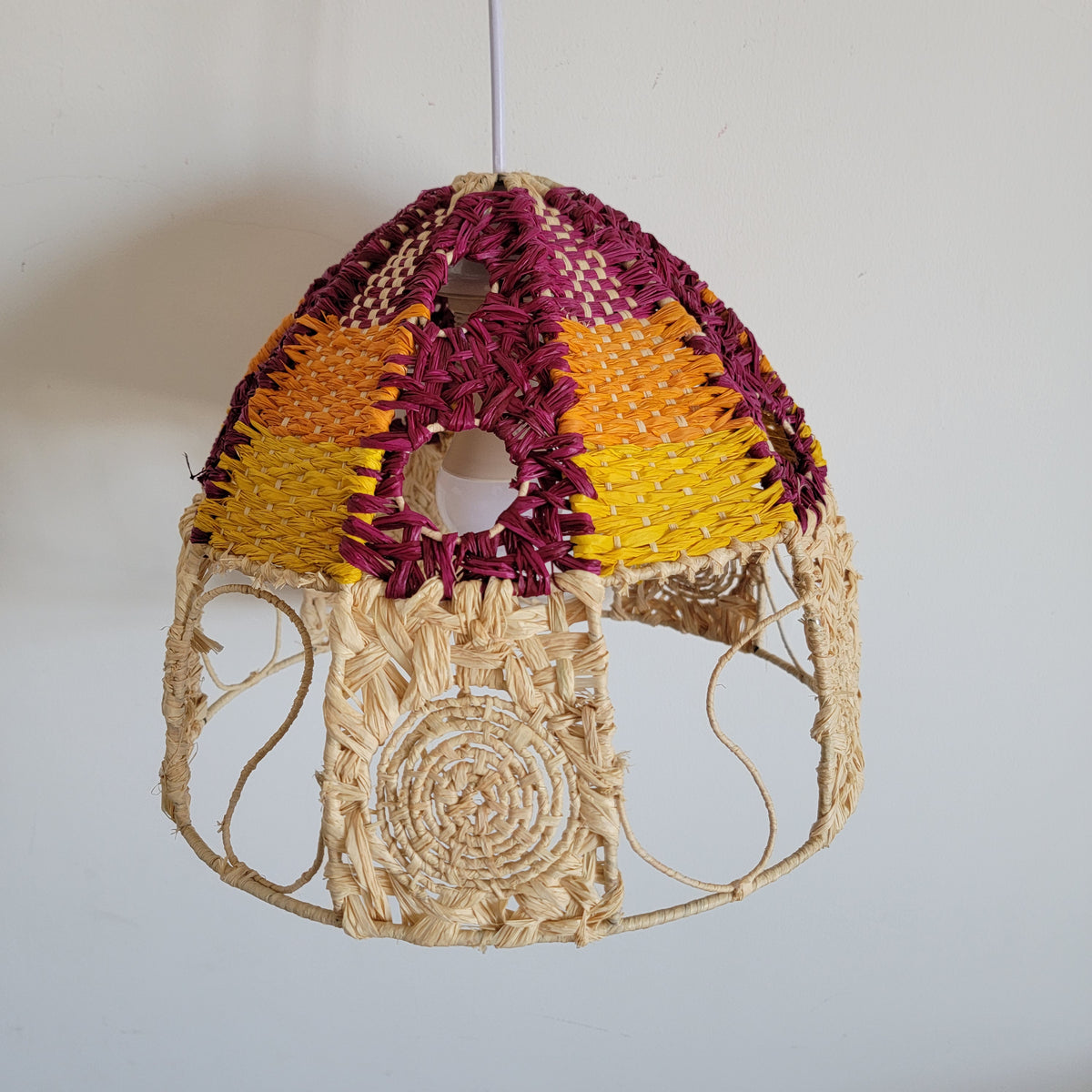 Handwoven raffia lamp shade in vibrant colors, showcasing artisanal boho chic design and unique craftsmanship.