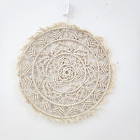 Handmade circular bohemian macrame wall hanging showcasing intricate patterns and delicate fringes, perfect for home decor.