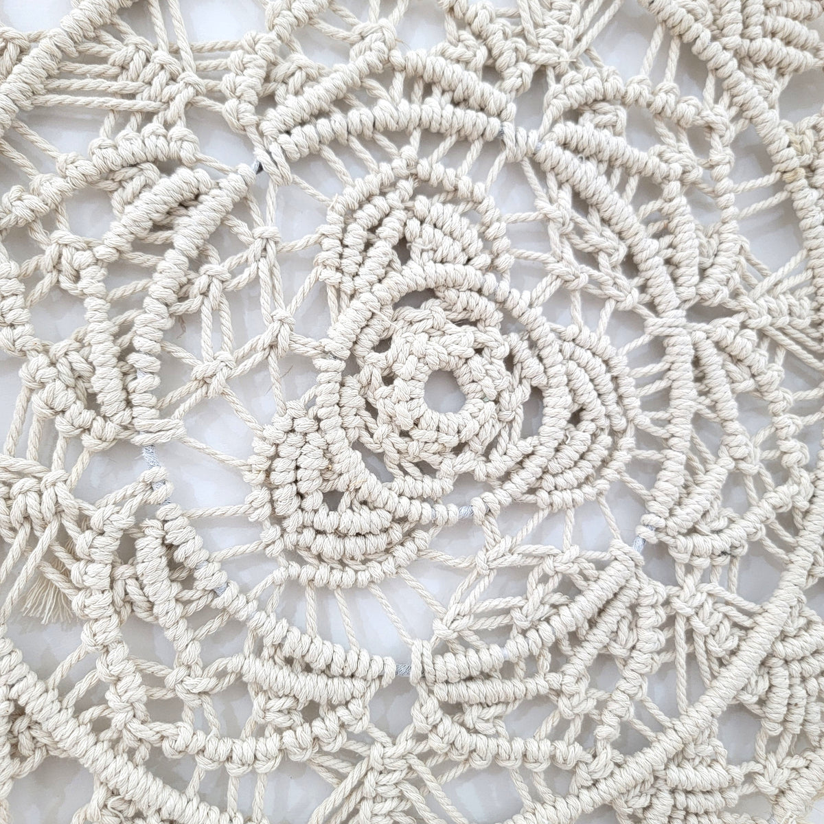 Handmade circular bohemian macrame wall hanging showcasing intricate patterns and delicate fringes, perfect for home decor.