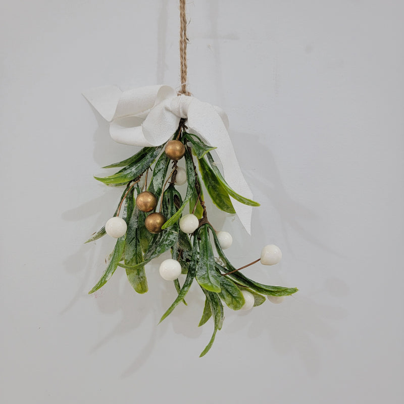Artificial mistletoe decoration with green leaves and white, gold berries, tied with a ribbon, perfect for holiday decor.