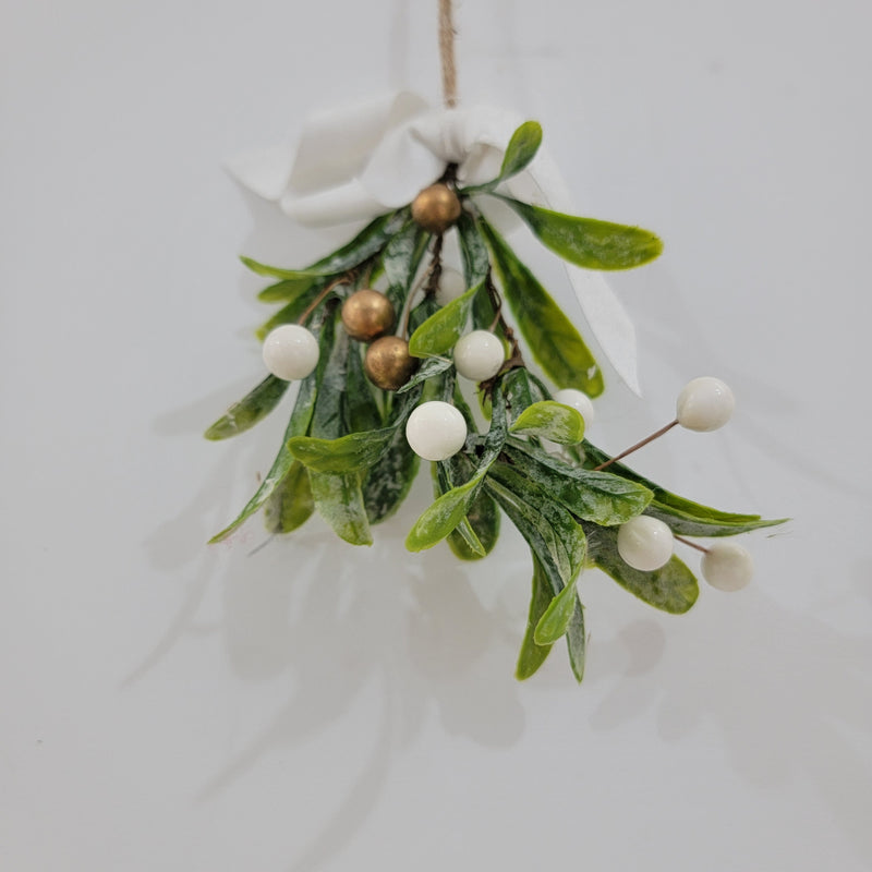 Artificial mistletoe decoration with green leaves and white, gold berries, tied with a ribbon, perfect for holiday decor.